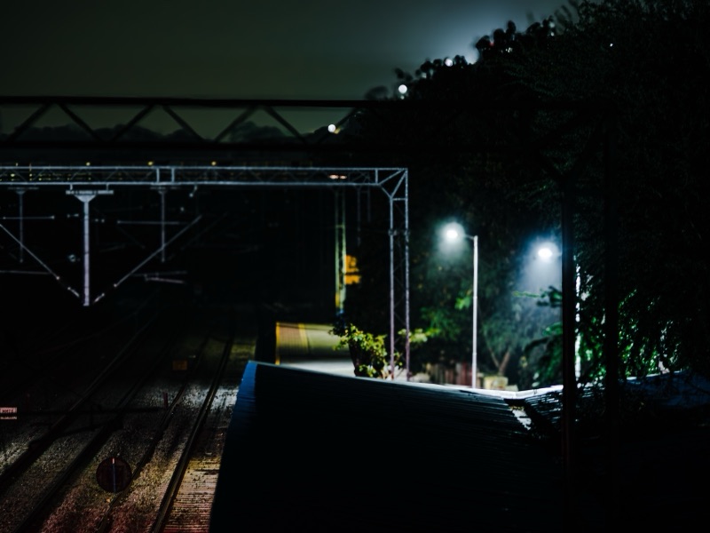 Empty Cavalry Barracks railway station platform at night with glowing streetlights