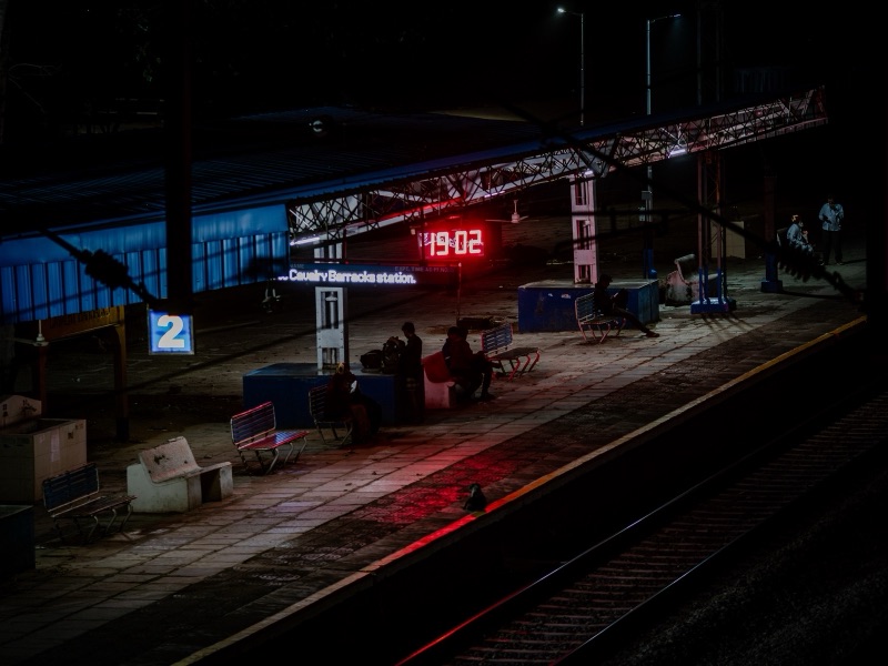 Cavalry Barracks railway platform at night with red digital clock and blue-lit tracks